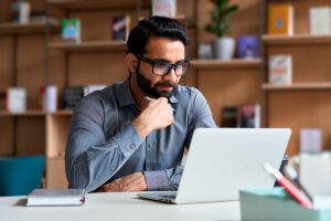 A millennial man looks at a laptop, illustrating Crafting Impactful Letters to Elected Officials with One Click Politics